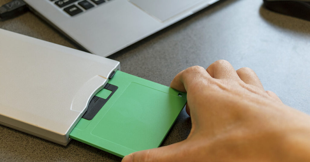 Man placing floppy disc into drive.